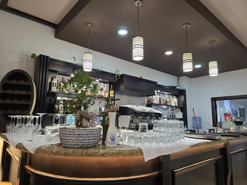 The bar counter with glasses, a bonsai and the coffee machine