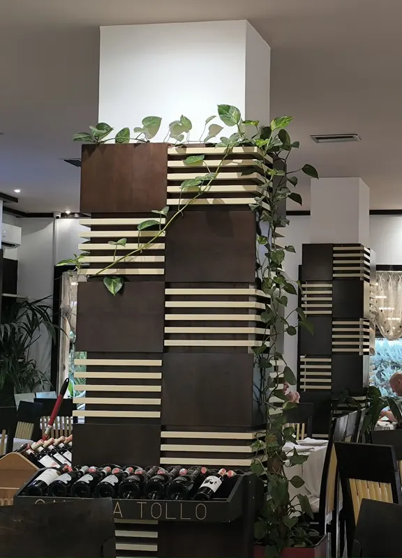 A column wrapped in ivy above the wine display in the dining room